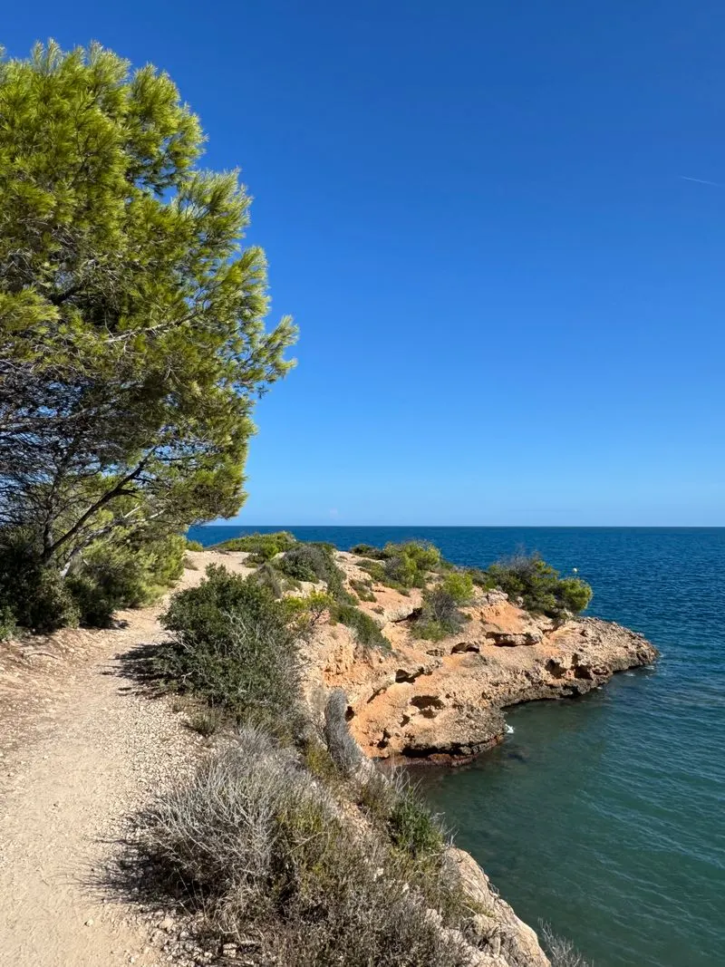 Camí de ronda al costat d'un mar blau i transparent